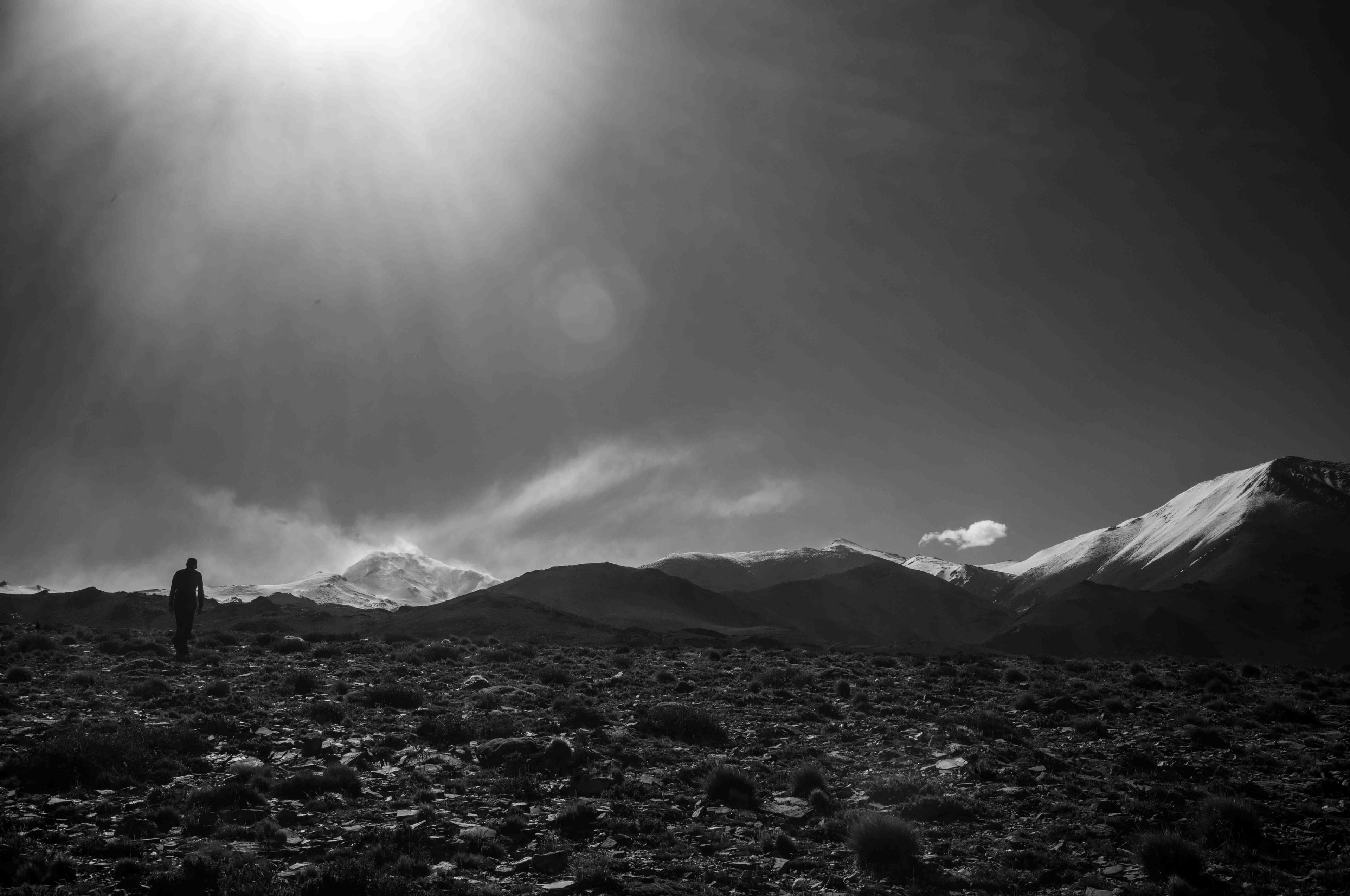 Caminante solitario en la inmensidad de la montaña, blanco y negro